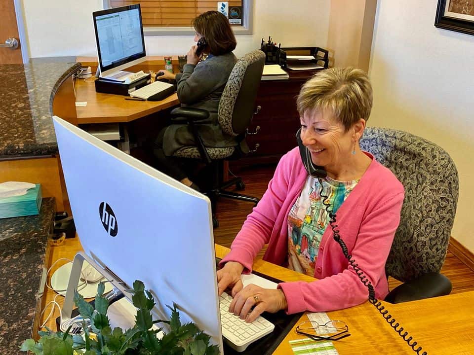 Two members of The Medicare Store team answering help-line calls at their desks
