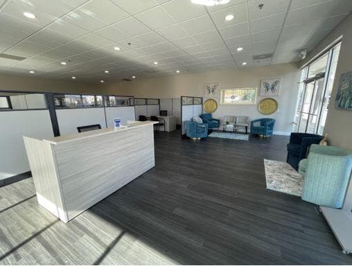 The reception area inside The Medicare Store's new South Meadows Parkway location in Reno, with a front desk, consultation cubicles, and a seating area